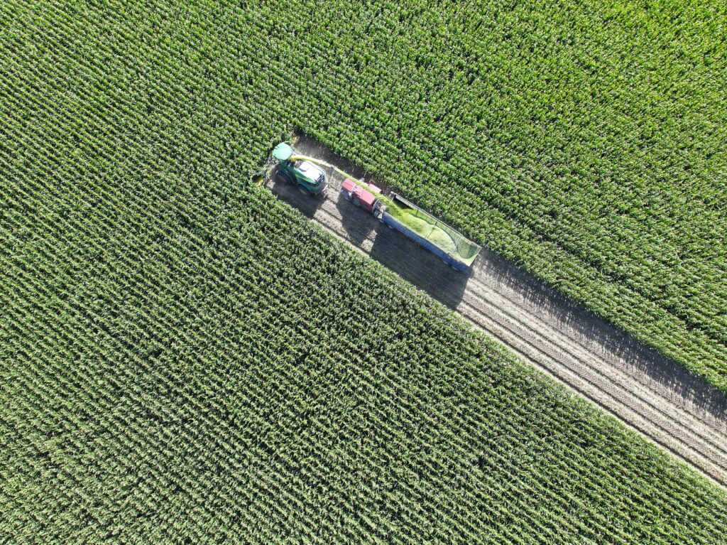 A truck driving down the road in an open field.