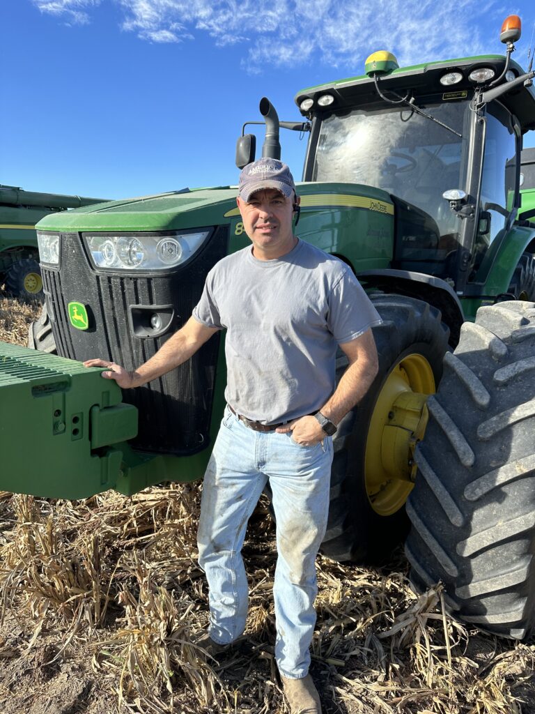 A man standing in front of a tractor.