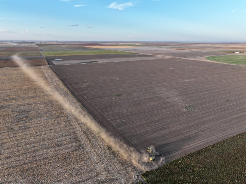 A large field with a tractor in the middle of it