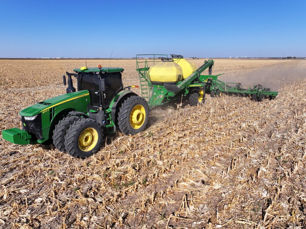 A tractor is pulling a trailer in the middle of a field.