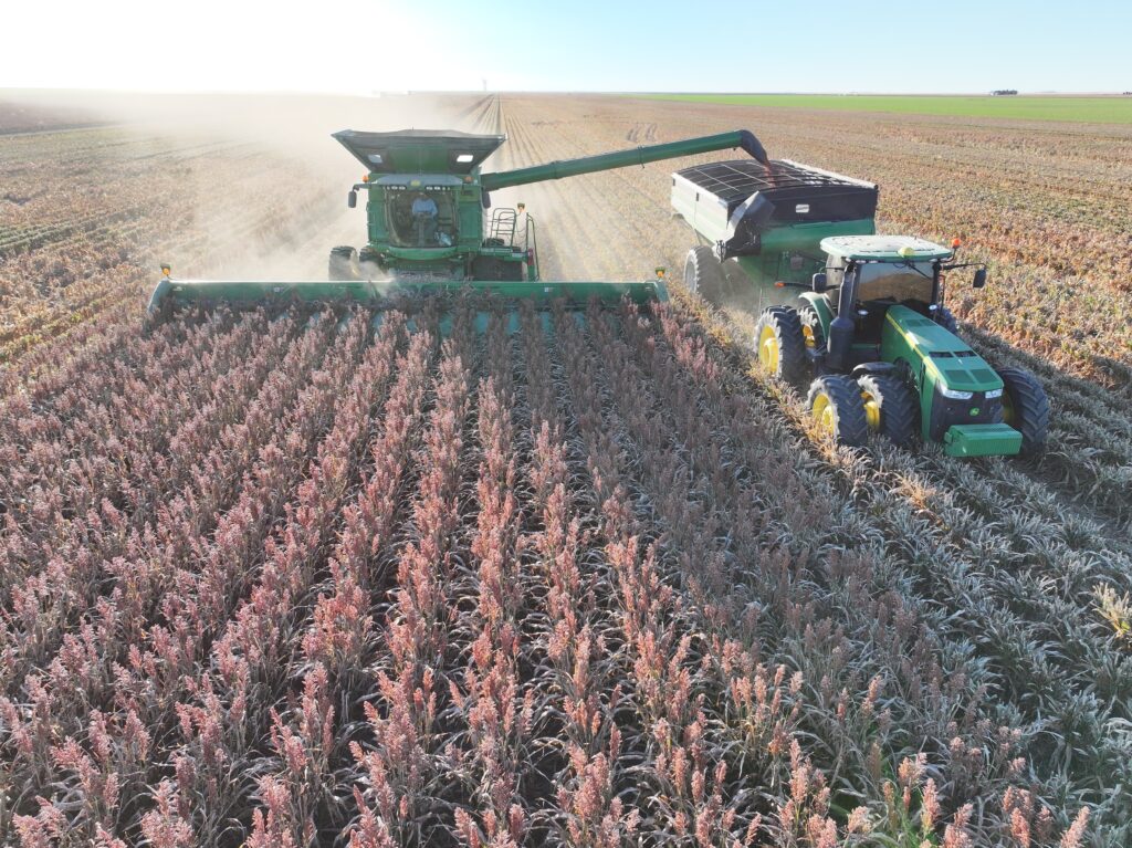 A tractor and a combine in the middle of a field.