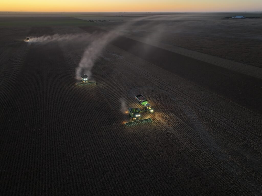 A tractor is spraying the field at night.